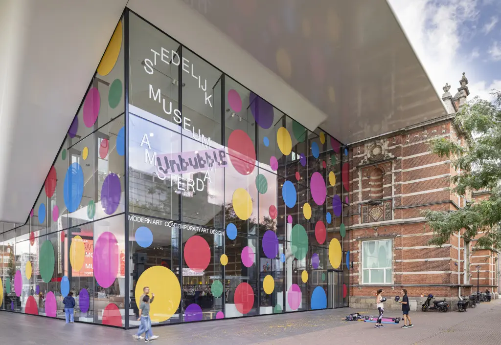 The Stedelijk Museum's facade on Museumplein covered in colored polka dots ahead of the Kusama retrospective