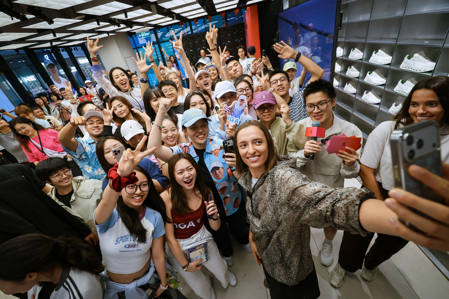 Iga Świątek sits with Chinese fans at a Beijing event, making friendship bracelets by hand.