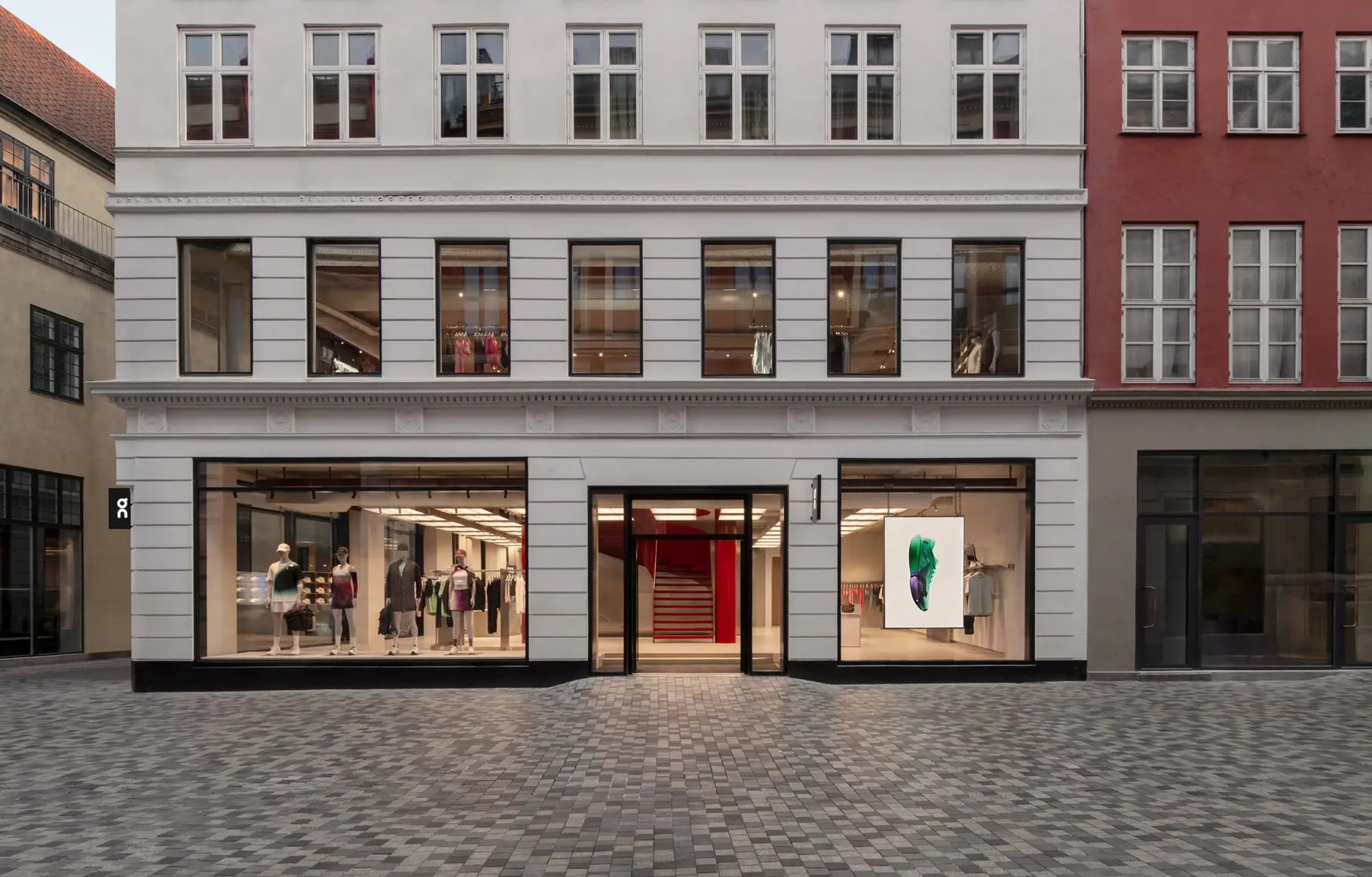 Exterior of On's new Copenhagen storefront on a pale brick street
