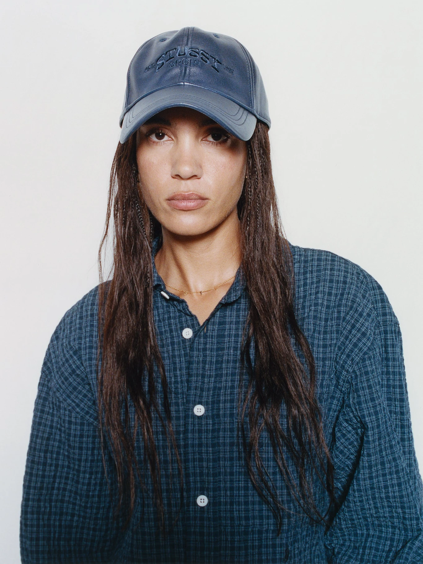 The Vol. 11 fireman jacket on a navy hanger against a white wall, double-breasted twill front visible.